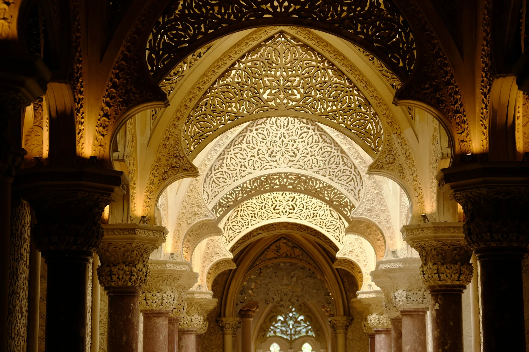 Sucesión de arcos ornamentados con relieves de inspiración morisca en la galería central del Palacio de Monserrate, en Sintra.