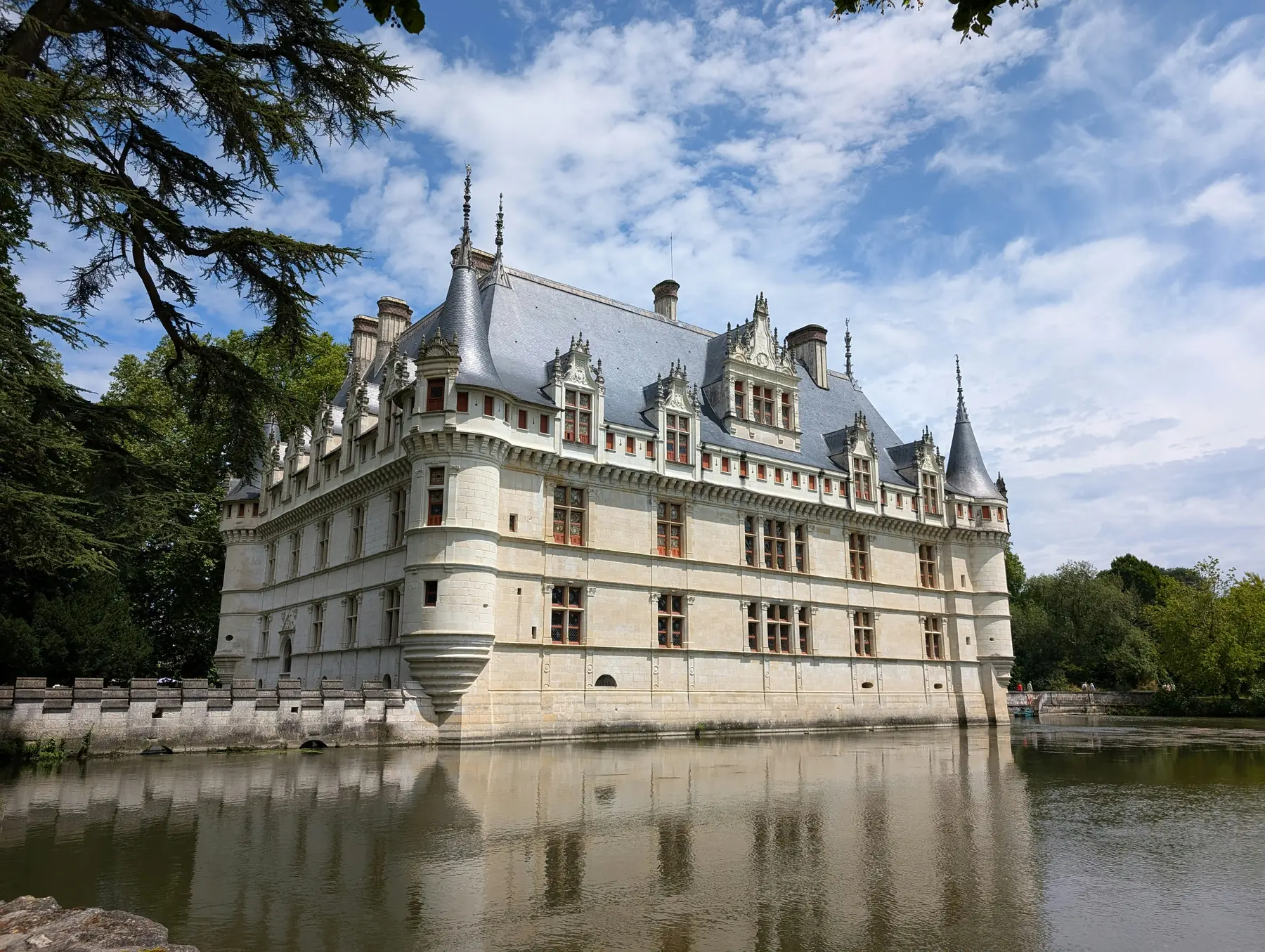 Castillo de Azay-le-Rideau, con sus torres y fachadas renacentistas reflejadas en el agua del río Indre.